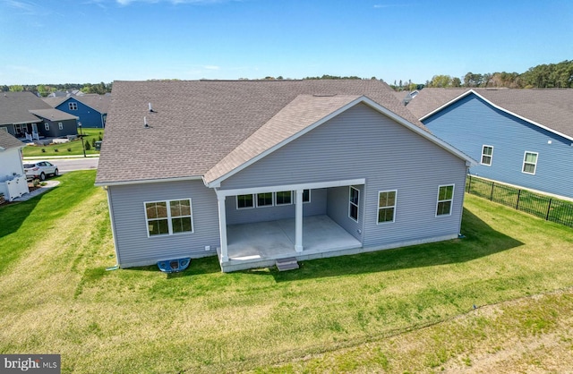 rear view of house with a lawn and a patio