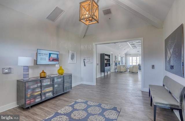 interior space with hardwood / wood-style floors, beam ceiling, and high vaulted ceiling