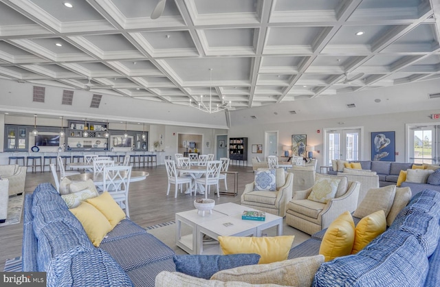 living room with beamed ceiling, coffered ceiling, and hardwood / wood-style flooring