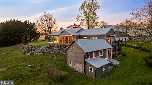 back house at dusk featuring a yard