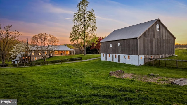 yard at dusk featuring an outdoor structure