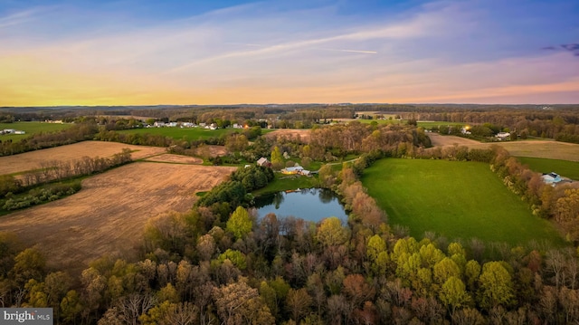 aerial view at dusk featuring a water view