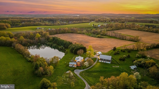 aerial view at dusk with a rural view and a water view