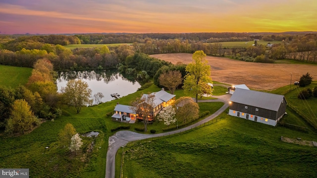 aerial view at dusk with a rural view and a water view