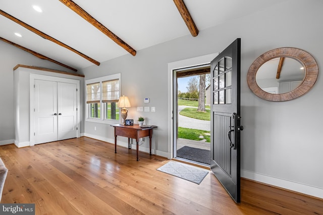 foyer featuring light hardwood / wood-style floors and vaulted ceiling with beams