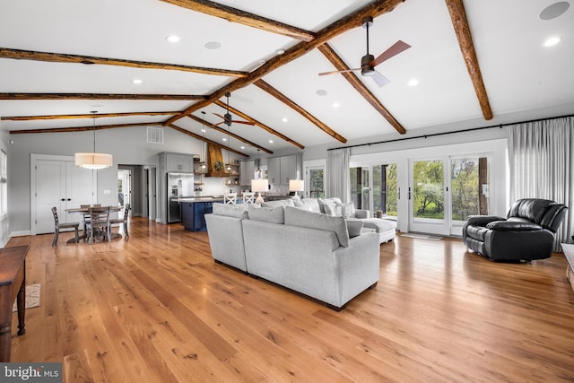 living room with beam ceiling, ceiling fan, and light wood-type flooring