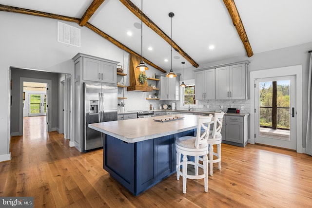 kitchen featuring light hardwood / wood-style floors, a center island, pendant lighting, and beam ceiling