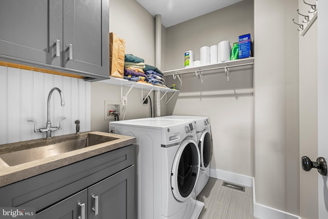 washroom featuring light tile floors, cabinets, washer and clothes dryer, sink, and washer hookup