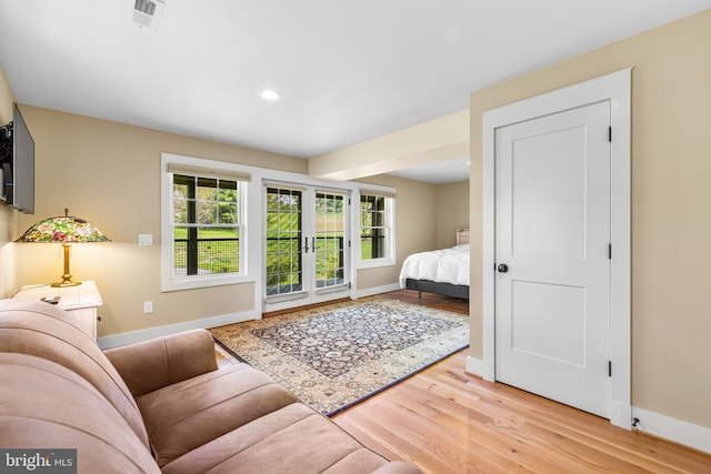 bedroom with french doors and light hardwood / wood-style floors