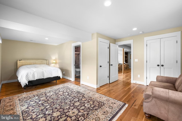 bedroom featuring ensuite bath and wood-type flooring