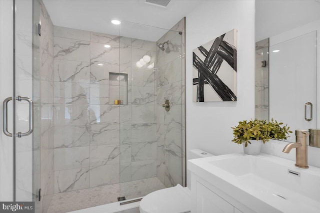 bathroom with sink, a shower with shower door, and toilet