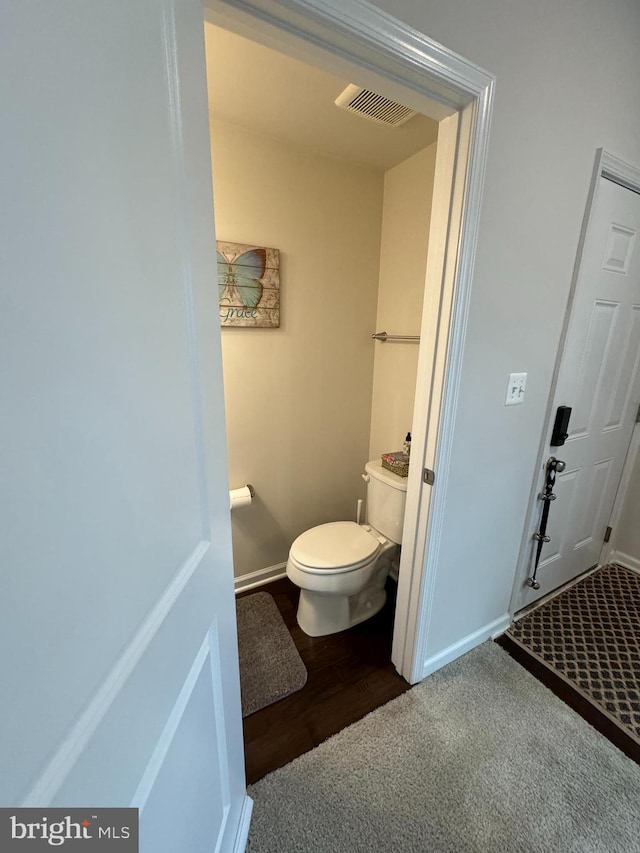 bathroom with toilet, baseboards, and visible vents