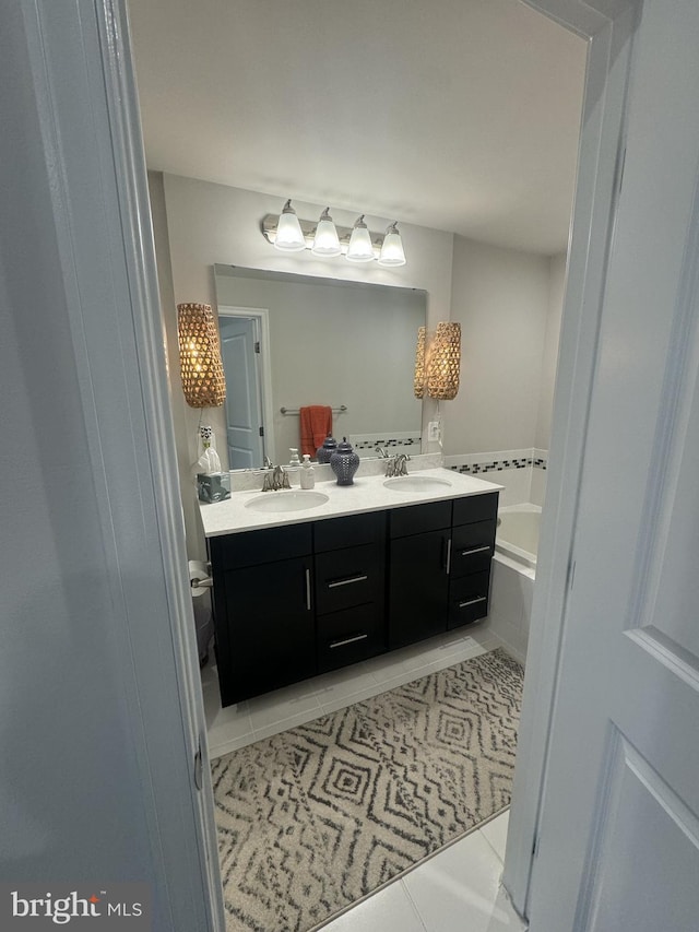 bathroom featuring a sink, a garden tub, double vanity, and tile patterned floors