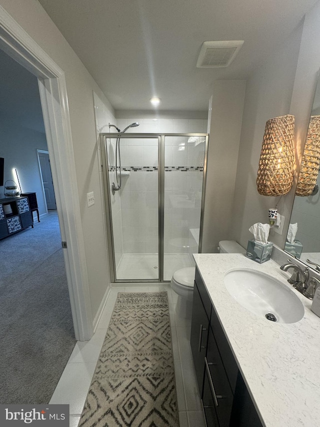 bathroom with tile patterned floors, visible vents, toilet, a shower stall, and vanity