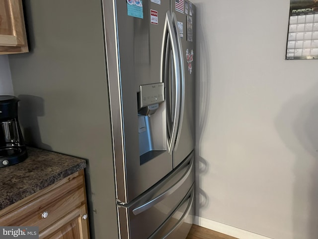 kitchen featuring wood-type flooring and stainless steel fridge