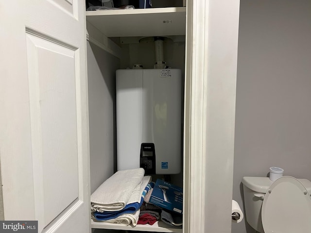 bathroom featuring toilet and water heater