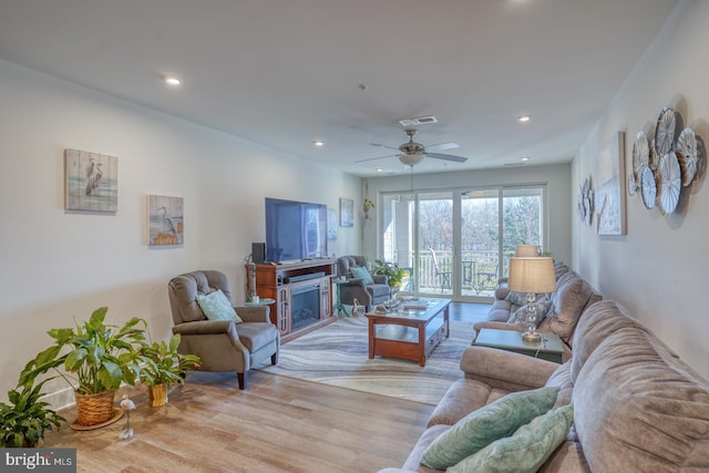 living room with light hardwood / wood-style flooring and ceiling fan