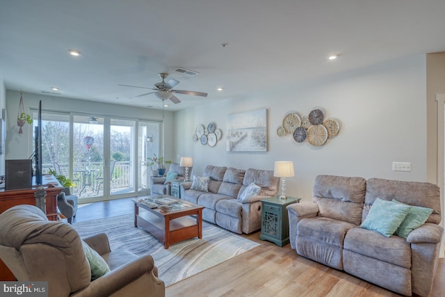 living room with ceiling fan and light wood-type flooring