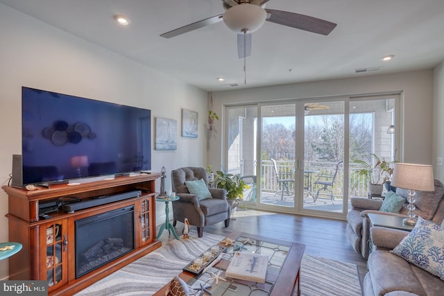 living room with light hardwood / wood-style floors and ceiling fan