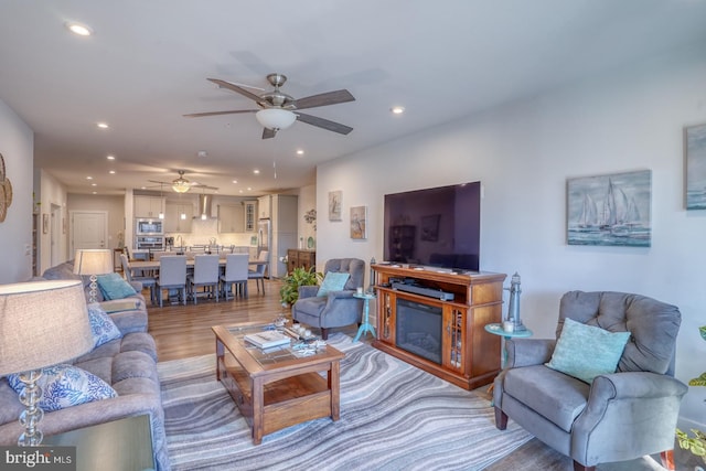 living room with ceiling fan and dark hardwood / wood-style floors