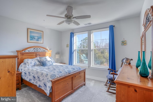 carpeted bedroom featuring multiple windows and ceiling fan