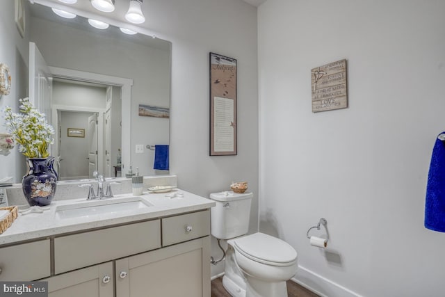 bathroom with hardwood / wood-style flooring, vanity, and toilet