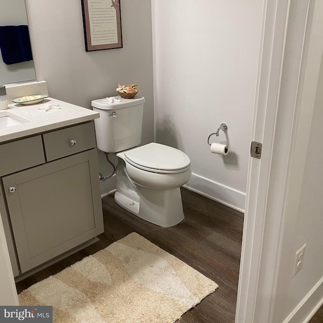 bathroom featuring toilet, vanity, and hardwood / wood-style floors