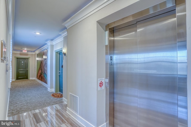 hallway featuring light carpet, elevator, and crown molding