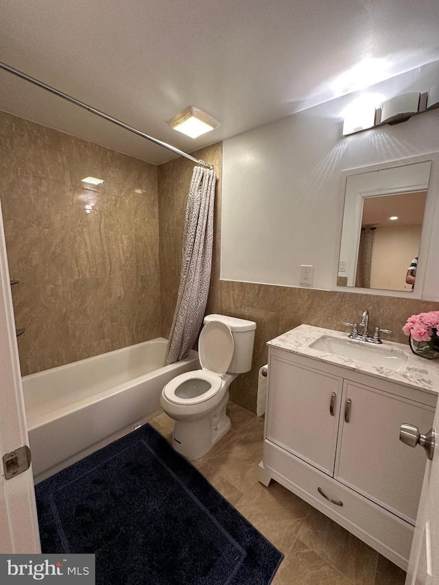 full bathroom with tile walls, toilet, tile flooring, shower / bath combo with shower curtain, and vanity