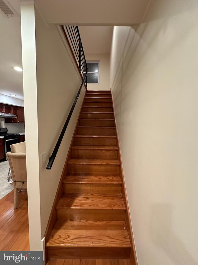 staircase with hardwood / wood-style flooring