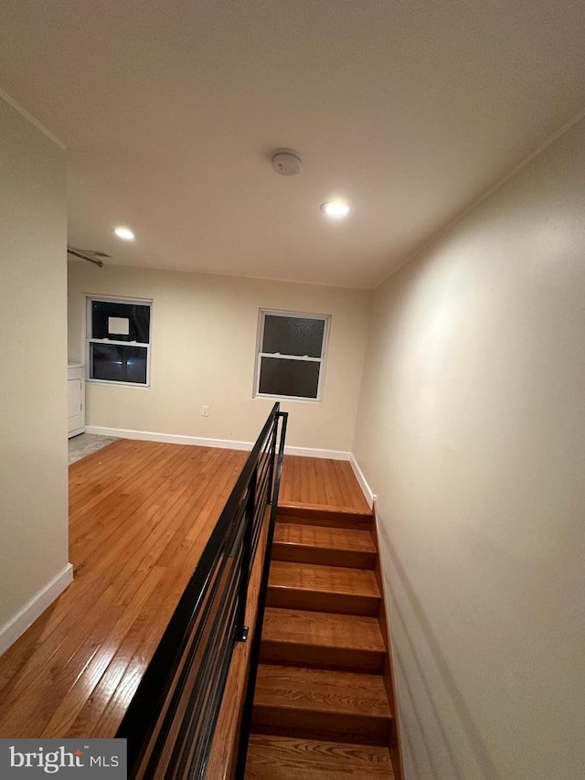 stairs featuring hardwood / wood-style floors