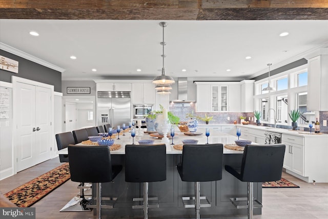 dining area with sink, ornamental molding, and light wood-type flooring