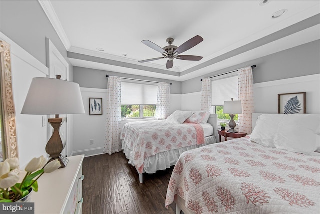 bedroom featuring a raised ceiling, ceiling fan, dark hardwood / wood-style flooring, and crown molding