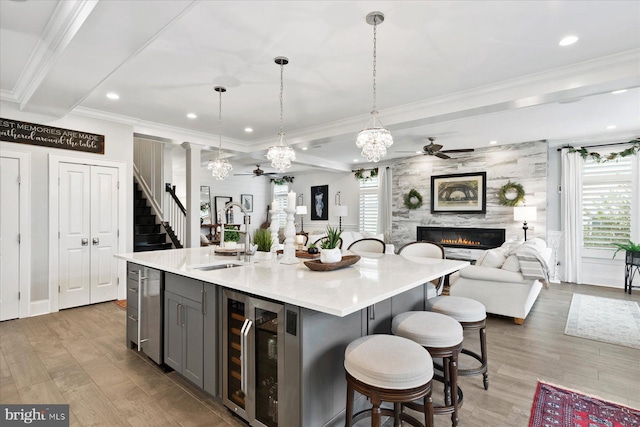 kitchen with gray cabinetry, a healthy amount of sunlight, a kitchen island with sink, and sink