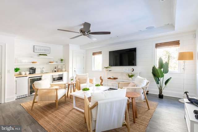 living room featuring ceiling fan, beverage cooler, hardwood / wood-style flooring, and sink