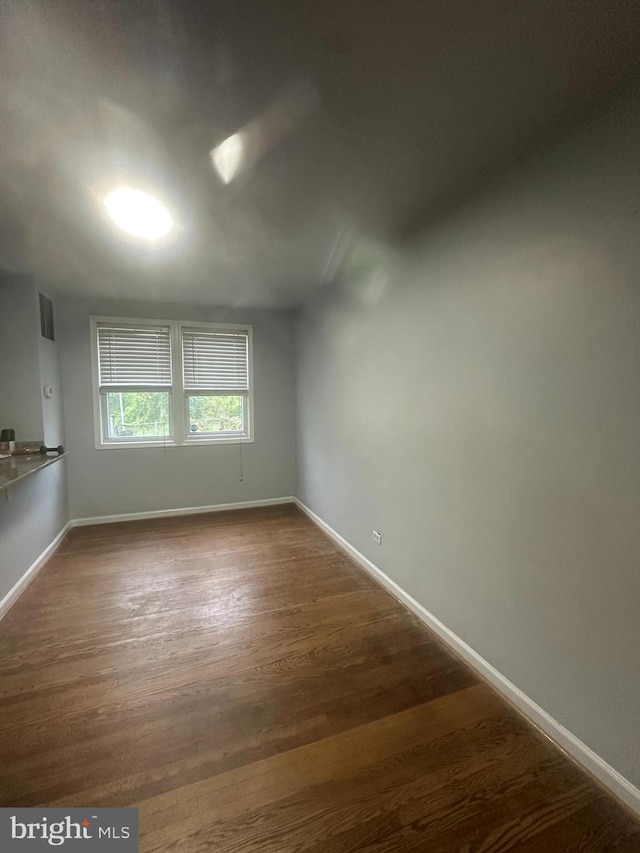 spare room with dark wood-type flooring