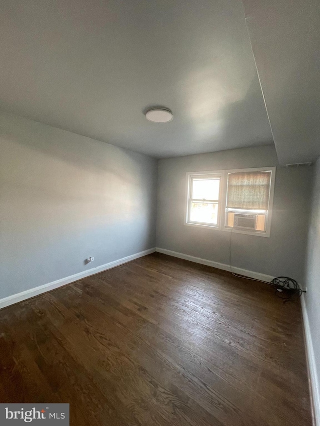 spare room featuring dark wood-type flooring and cooling unit