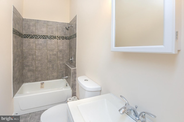 full bathroom with toilet, tile floors, tiled shower / bath combo, and sink