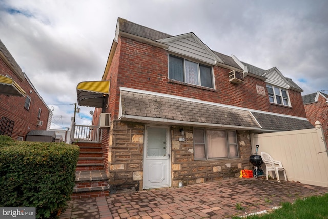 rear view of property featuring a wall mounted air conditioner and a patio area