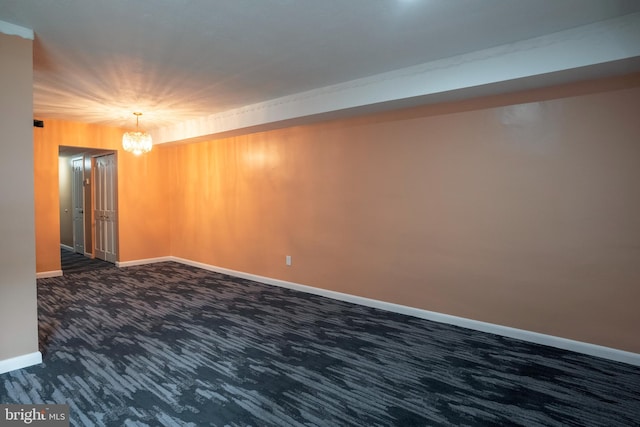 carpeted empty room with an inviting chandelier