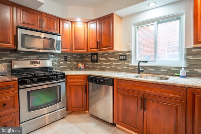 kitchen featuring tasteful backsplash, stainless steel appliances, and light stone countertops