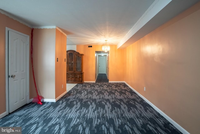 carpeted spare room with a notable chandelier