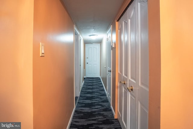 corridor with dark colored carpet