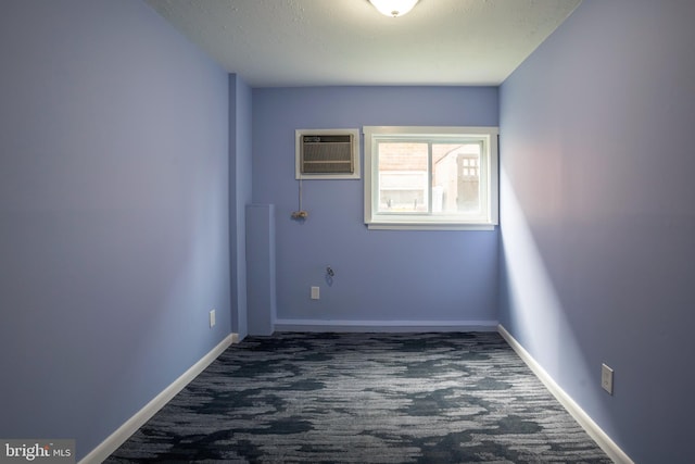 spare room featuring carpet flooring and an AC wall unit