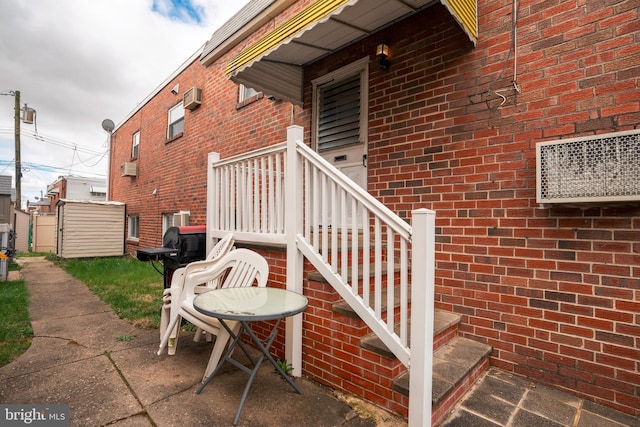 view of home's exterior with a wall unit AC and a patio area