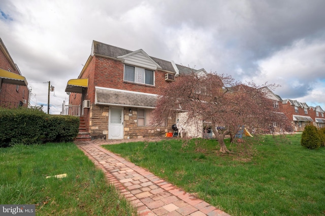 view of front of house featuring a front yard and an AC wall unit