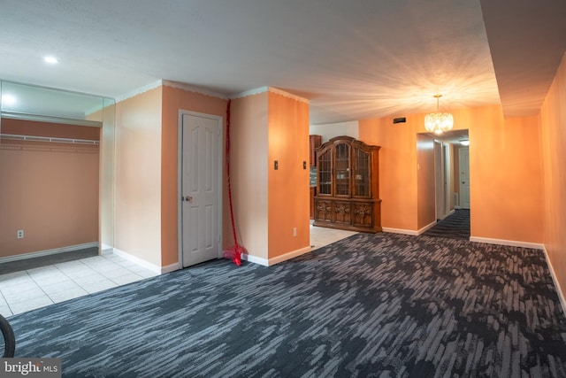 carpeted empty room featuring a chandelier