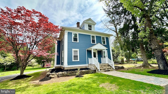 view of front of home featuring covered porch and a front yard