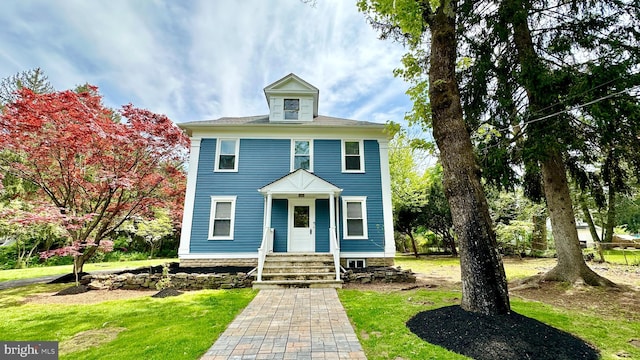 view of front of home with a porch and a front yard