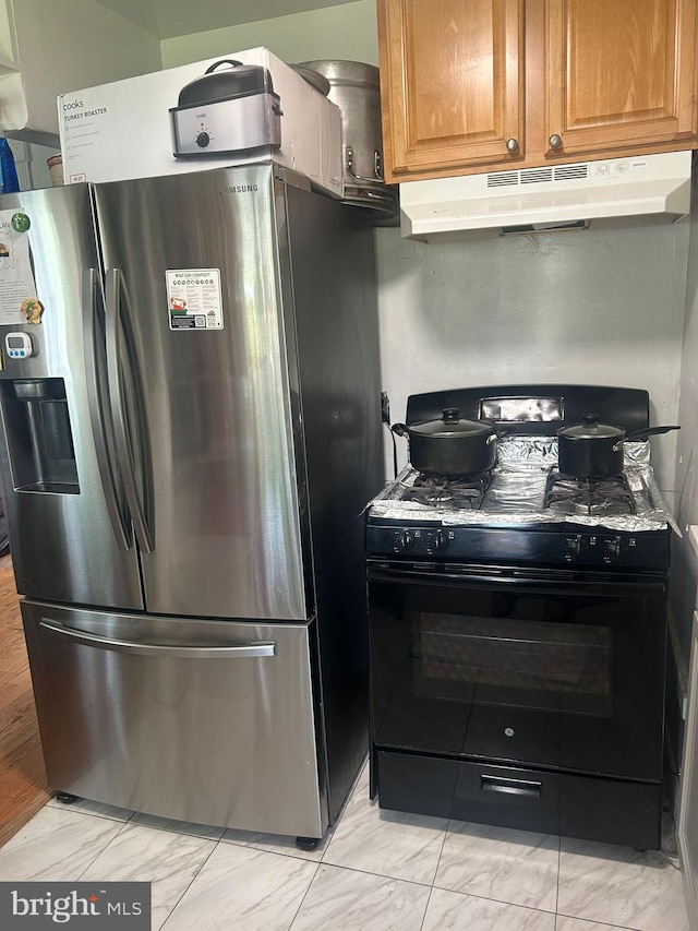 kitchen with stainless steel refrigerator with ice dispenser, gas range oven, and light tile floors